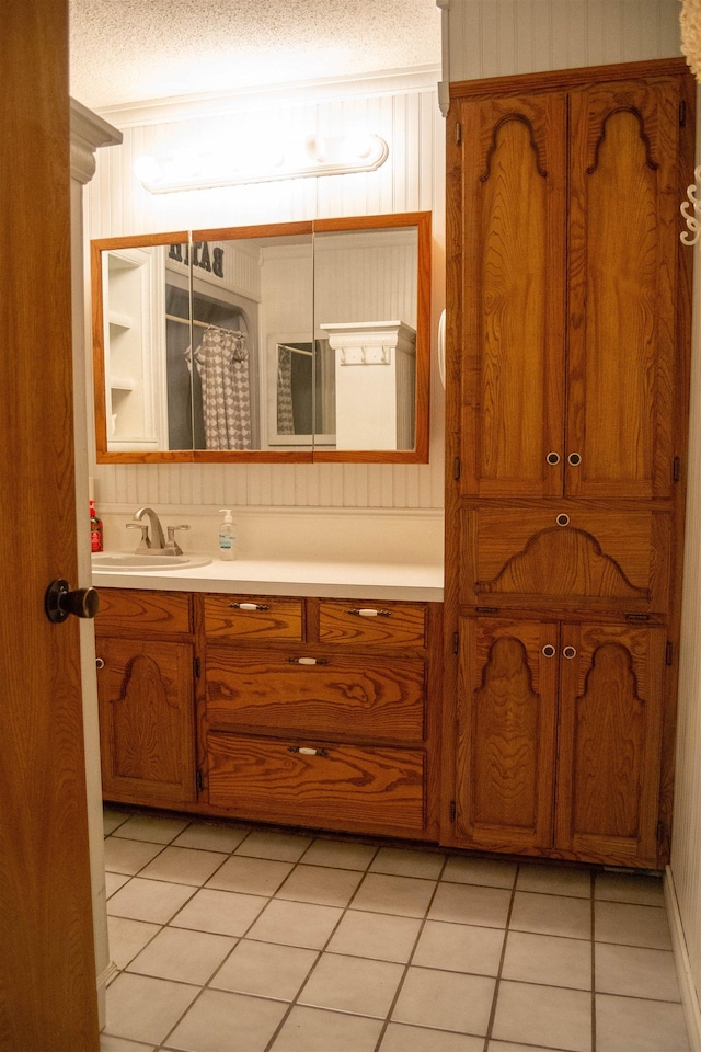 bathroom with tile patterned flooring, vanity, and a textured ceiling