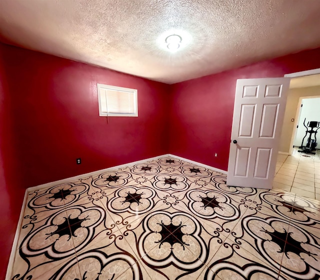 tiled spare room with a textured ceiling