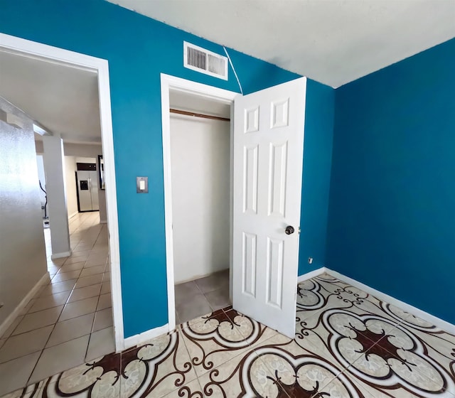 unfurnished bedroom featuring light tile patterned floors and a closet