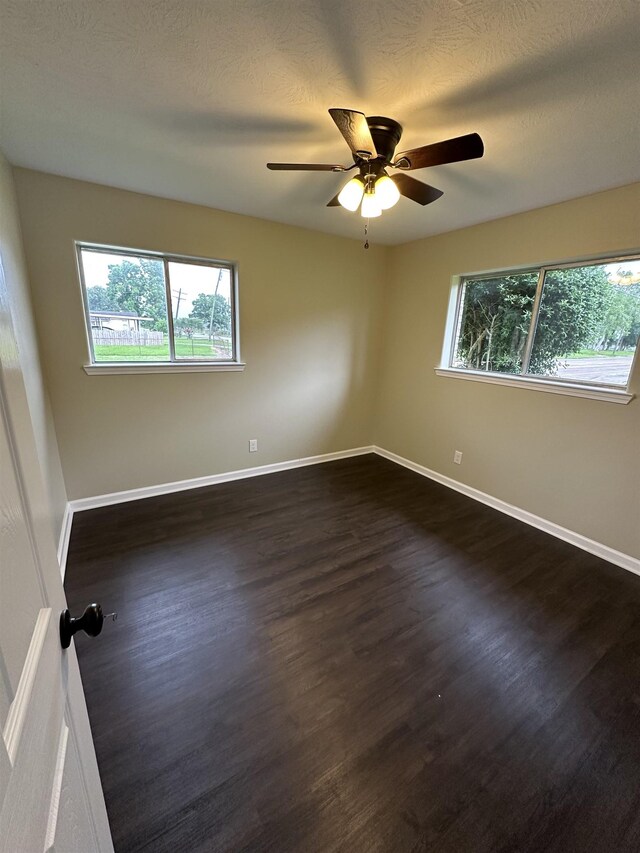 2390 Sarah St, Beaumont, TX 77705 - unfurnished room featuring healthy amount of natural light, dark wood finished floors, ceiling fan, and baseboards