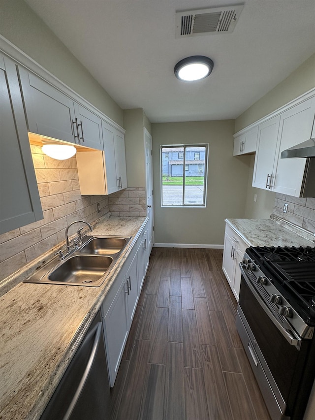 2390 Sarah St, Beaumont, TX 77705 - kitchen featuring range with gas stovetop, a sink, dishwasher, dark wood-style flooring, and baseboards