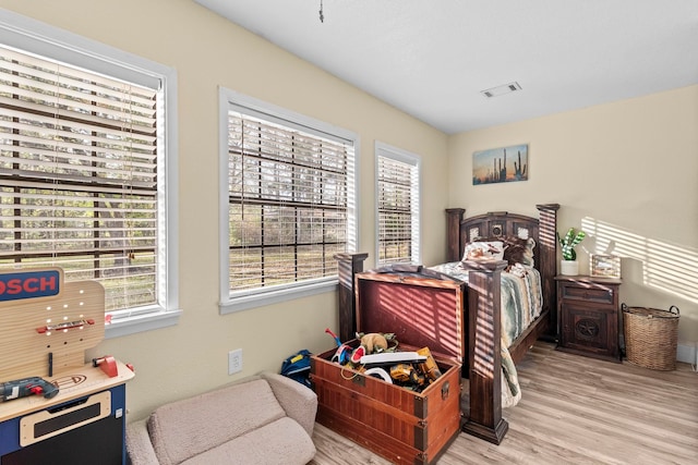 bedroom featuring visible vents, multiple windows, and light wood finished floors