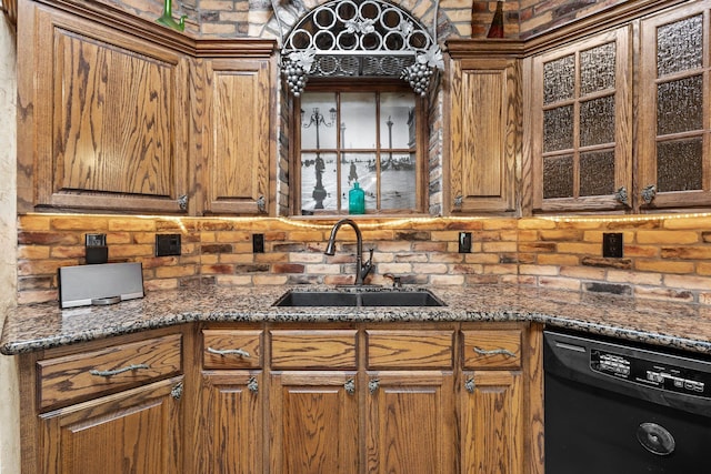 kitchen featuring dishwasher, a sink, brown cabinets, and glass insert cabinets