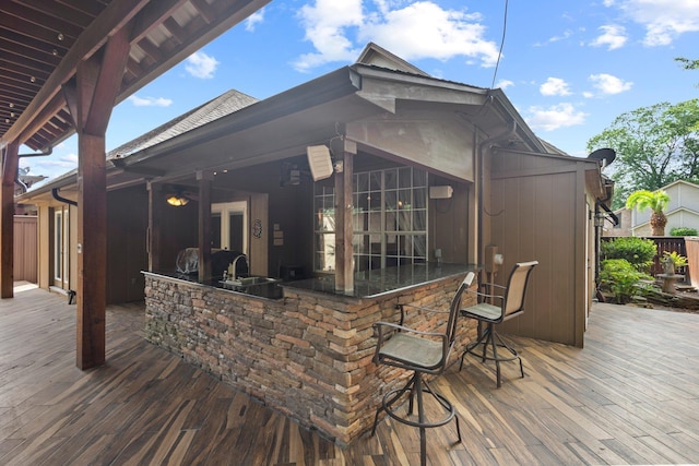 wooden terrace featuring fence and exterior kitchen