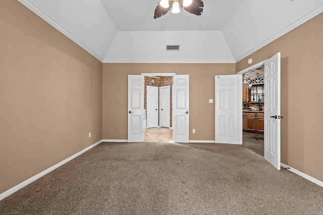 unfurnished bedroom with carpet floors, ornamental molding, baseboards, a ceiling fan, and vaulted ceiling