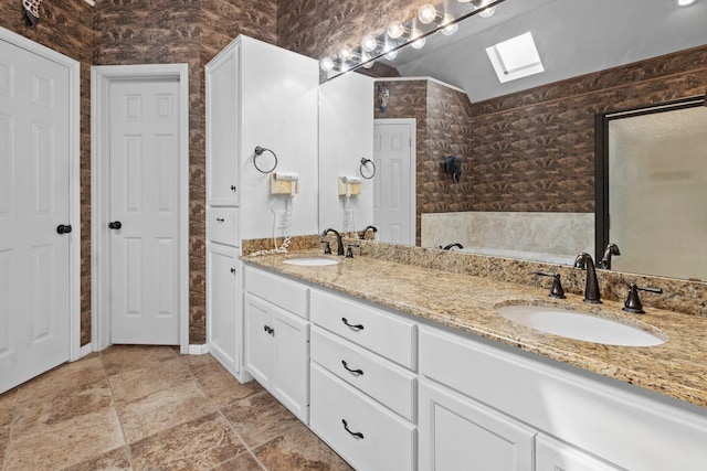 full bathroom featuring a skylight, double vanity, and a bath