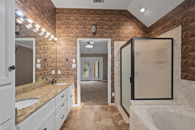 bathroom with a stall shower, a garden tub, double vanity, and a ceiling fan