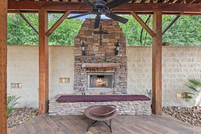 view of patio / terrace featuring an outdoor stone fireplace and a ceiling fan