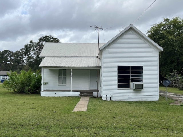 back of property with cooling unit, covered porch, and a yard