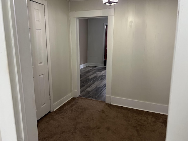 hallway featuring dark colored carpet