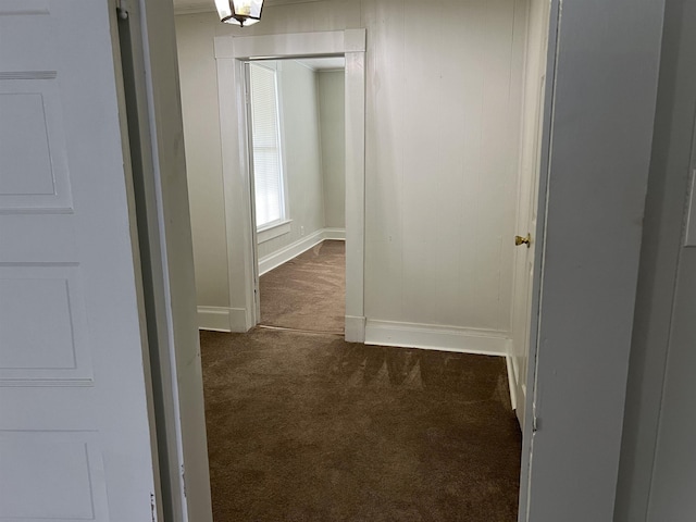 hallway featuring dark colored carpet