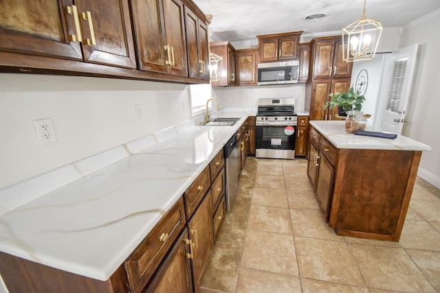 kitchen with appliances with stainless steel finishes, sink, decorative light fixtures, a center island, and ornamental molding