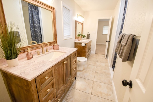 bathroom featuring toilet, tile patterned flooring, and vanity