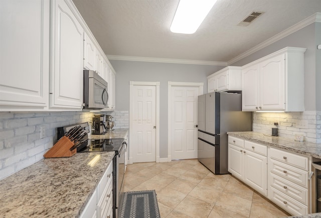 8320 Carrie Ln, Beaumont, TX 77713 - kitchen featuring stainless steel appliances, white cabinets, tasteful backsplash, light stone counters, and ornamental molding