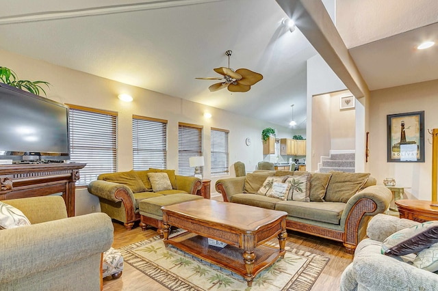 living room featuring ceiling fan, plenty of natural light, vaulted ceiling, and light wood-type flooring