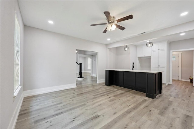 2033 Broadway St, Beaumont, TX 77702 - kitchen with white cabinets, light wood-style floors, ceiling fan, baseboards, and recessed lighting