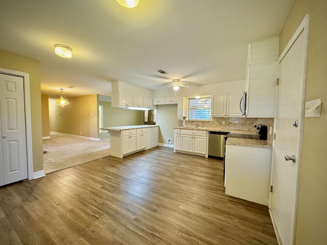 kitchen featuring decorative backsplash, appliances with stainless steel finishes, ceiling fan, pendant lighting, and white cabinetry