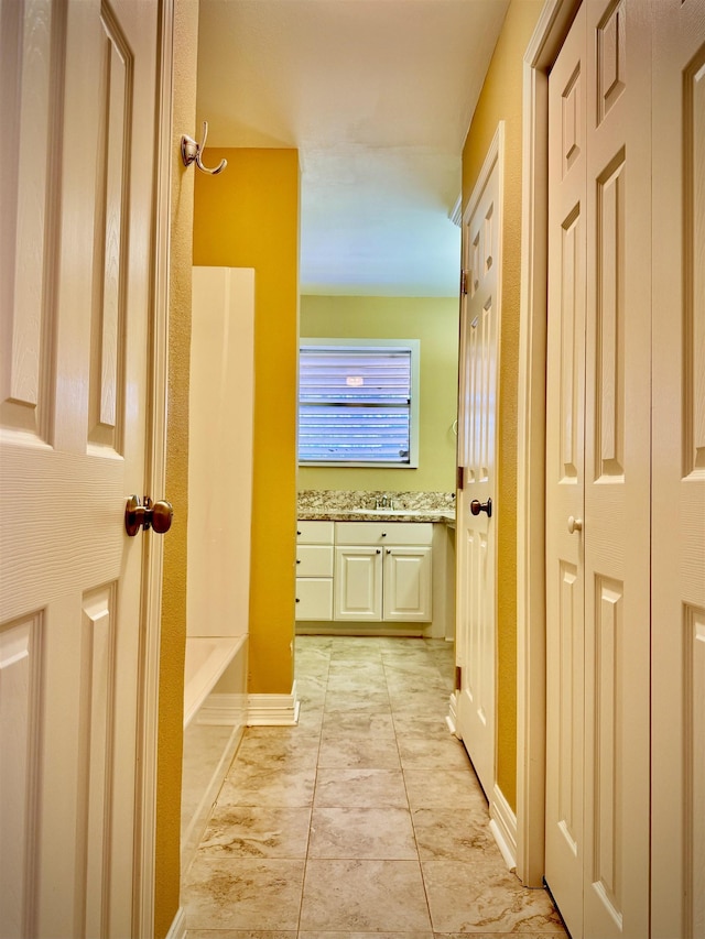 hall with light tile patterned floors and sink