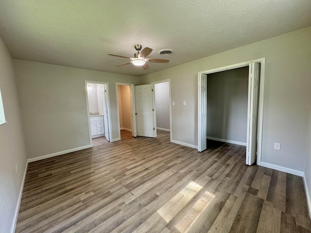 13595 Rolling Hills Dr, Beaumont, TX 77713 - unfurnished bedroom featuring baseboards, wood finished floors, a textured ceiling, a ceiling fan, and a closet