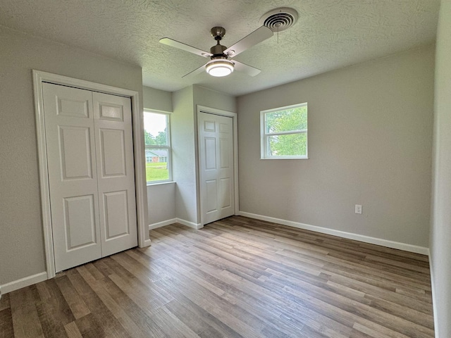 13595 Rolling Hills Dr, Beaumont, TX 77713 - unfurnished bedroom featuring wood finished floors, baseboards, a textured ceiling, and ceiling fan