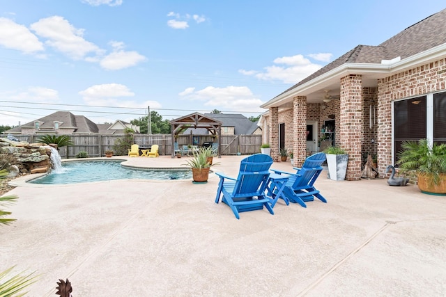 view of swimming pool with a gazebo, a patio area, pool water feature, and a fireplace