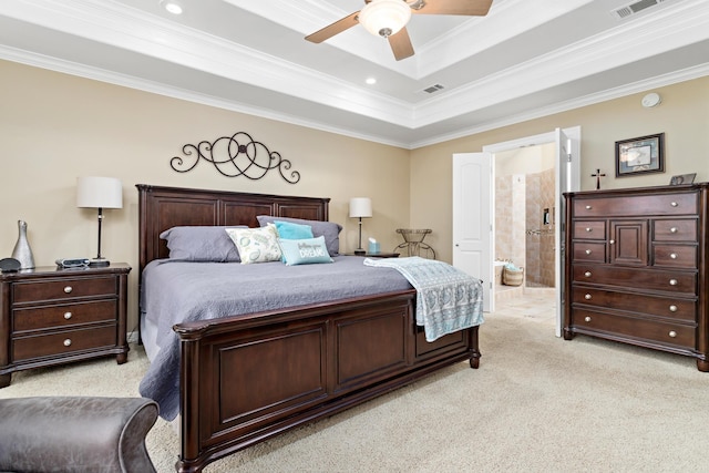 carpeted bedroom with a raised ceiling, ensuite bath, ceiling fan, and ornamental molding