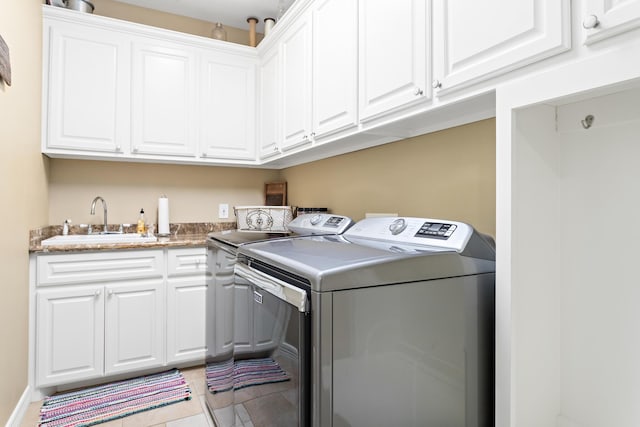 laundry room featuring cabinets, sink, light tile patterned floors, and washer and dryer