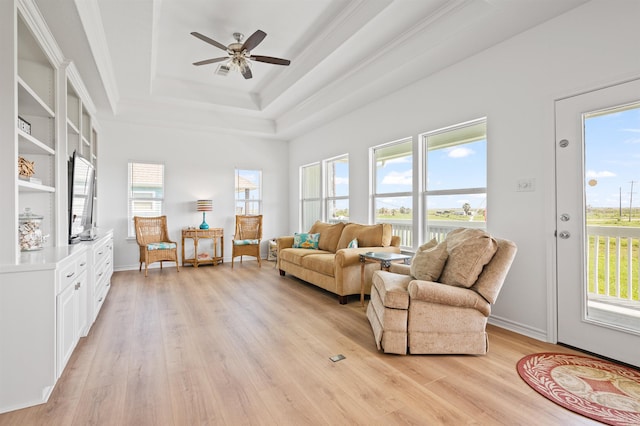 981 S S Gtwy, Crystal Beach, TX 77650 - living room featuring light wood-style floors, plenty of natural light, a raised ceiling, ceiling fan, and crown molding