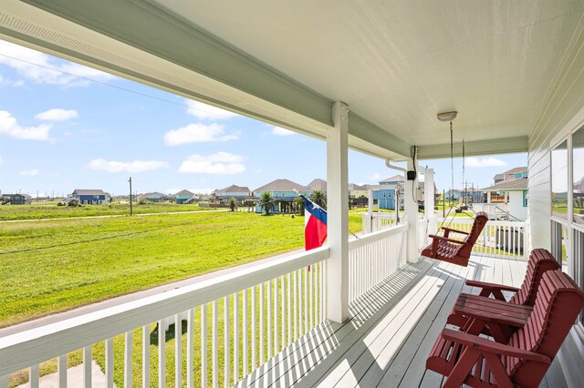 981 S S Gtwy, Crystal Beach, TX 77650 - deck with a residential view, a lawn, and covered porch