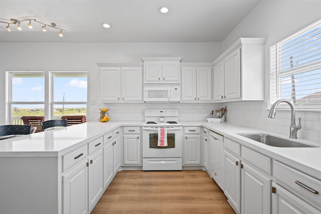 981 S S Gtwy, Crystal Beach, TX 77650 - kitchen featuring white appliances, a sink, a peninsula, white cabinets, and recessed lighting
