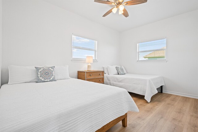 981 S S Gtwy, Crystal Beach, TX 77650 - bedroom with multiple windows, light wood-style flooring, baseboards, and a ceiling fan