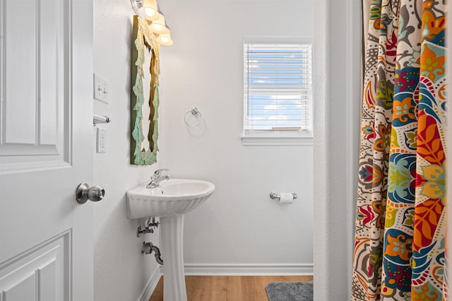 981 S S Gtwy, Crystal Beach, TX 77650 - full bath featuring wood finished floors, baseboards, a sink, and a shower with shower curtain
