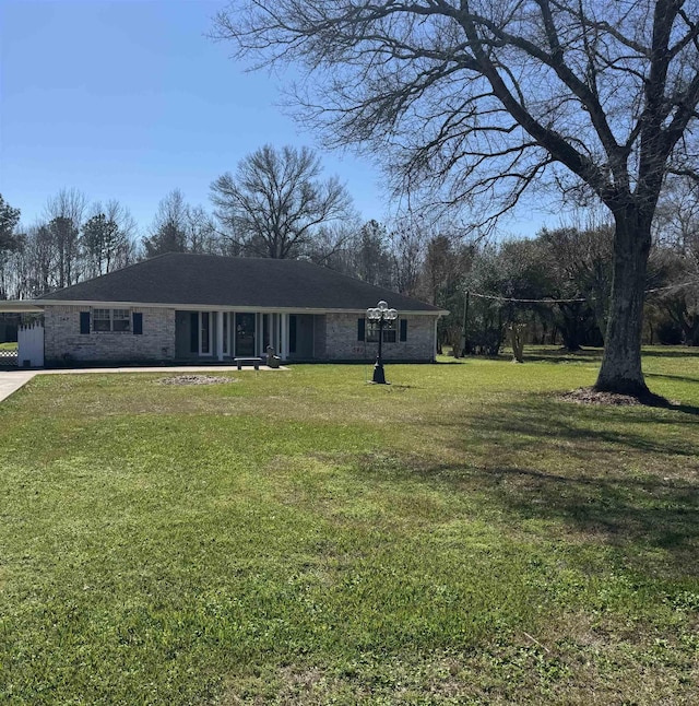 ranch-style house with driveway, an attached carport, and a front yard