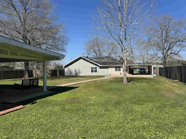 view of yard featuring a carport and fence