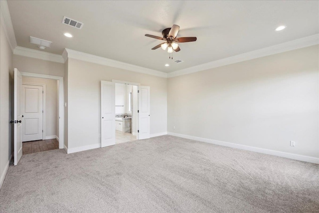 unfurnished bedroom featuring crown molding, light carpet, ceiling fan, and ensuite bathroom