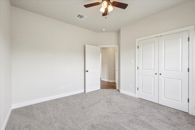 unfurnished bedroom with carpet floors, ceiling fan, and a closet