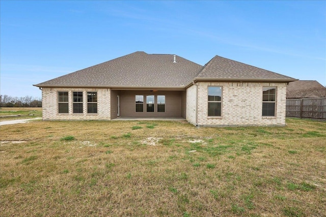 back of property featuring a lawn and a patio