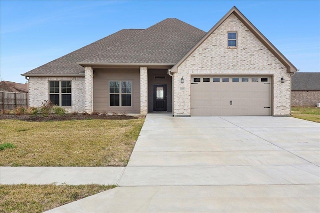 view of front of home with a garage and a front lawn