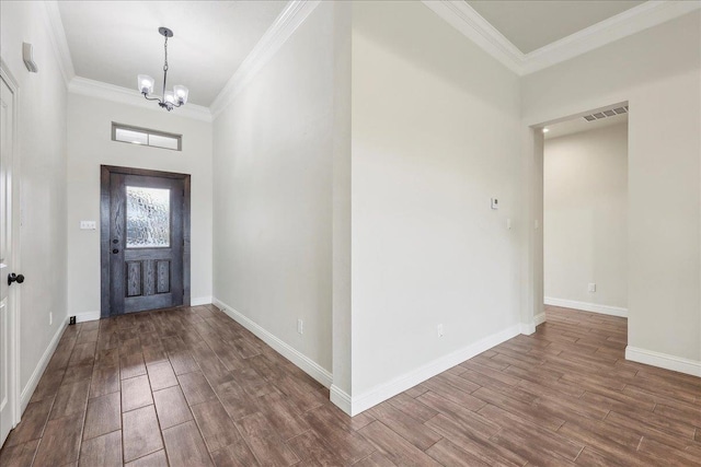 entrance foyer featuring hardwood / wood-style floors, crown molding, and a chandelier