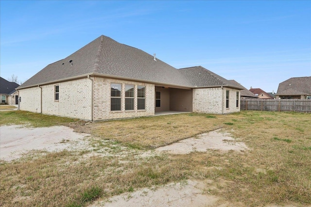 rear view of property with a yard and a patio