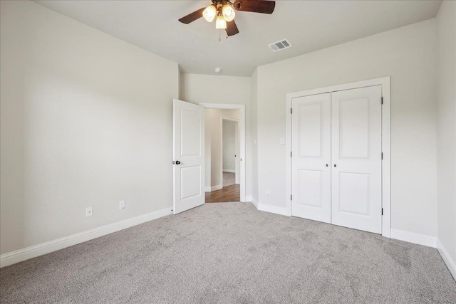 unfurnished bedroom featuring ceiling fan, carpet flooring, and a closet