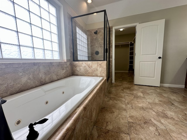 305 Tyler Dr, Bridge City, TX 77630 - full bath featuring a shower stall, a jetted tub, a walk in closet, stone finish floors, and baseboards