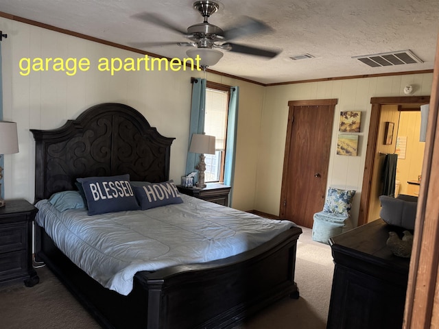 bedroom with ornamental molding, carpet flooring, ceiling fan, and a textured ceiling