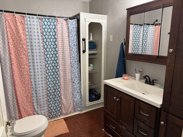 bathroom with wood-type flooring, walk in shower, vanity, and toilet