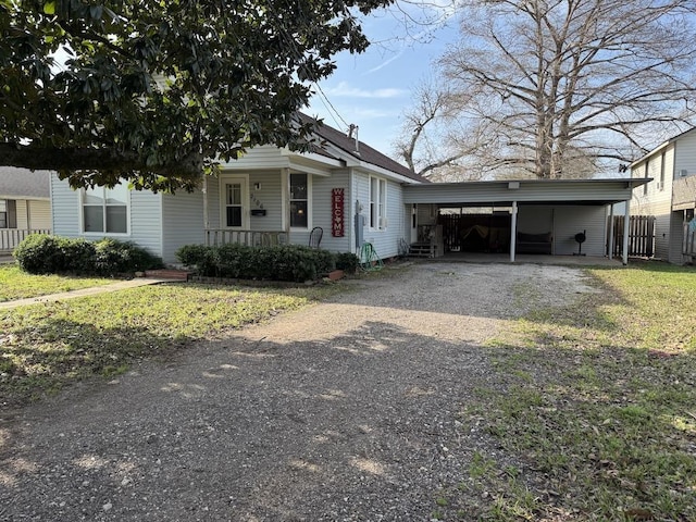 view of front of house with a carport, a porch, and a front lawn