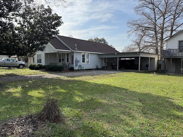 back of property featuring a carport and a lawn