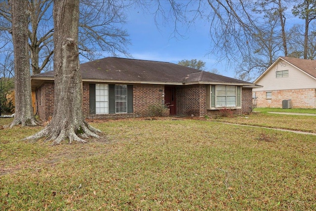 ranch-style home with a front yard, brick siding, and central AC unit