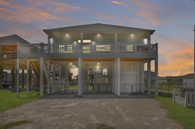 back house at dusk featuring a carport