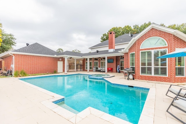 view of swimming pool with an in ground hot tub, ceiling fan, and a patio area