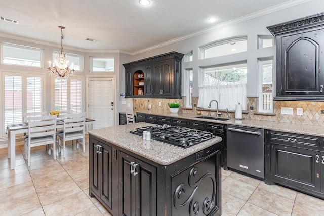 kitchen with sink, hanging light fixtures, stainless steel appliances, a chandelier, and a kitchen island